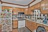 Kitchen with backsplash, white appliances, ornamental molding, a textured ceiling, and light countertops