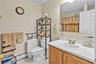 Bathroom with a baseboard radiator, a shower with shower curtain, light tile patterned flooring, and vanity