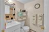 Bathroom featuring vanity, a textured ceiling, baseboard heating, a shower with shower curtain, and decorative backsplash