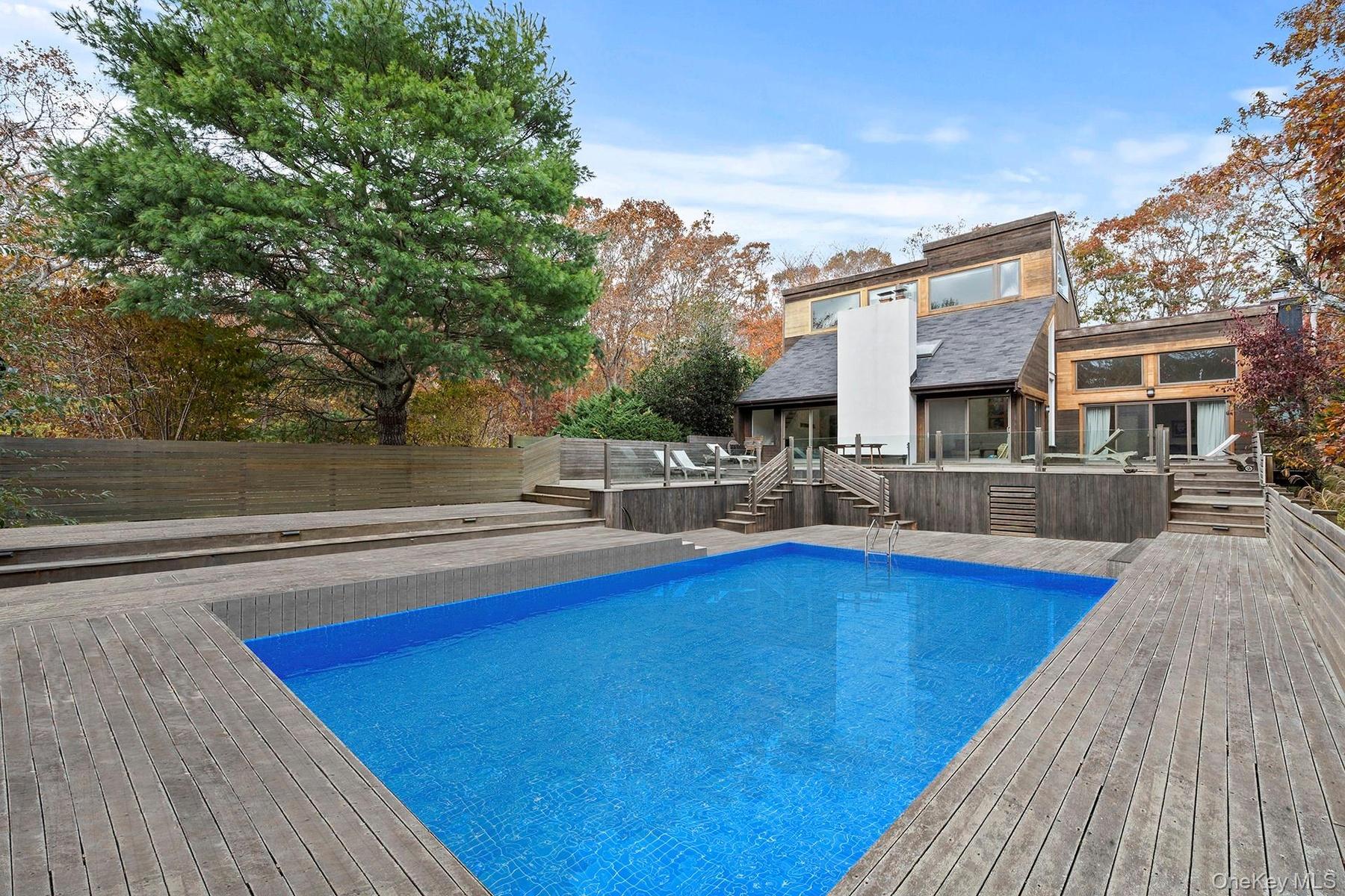 View of pool featuring stairway, a deck, and a patio area