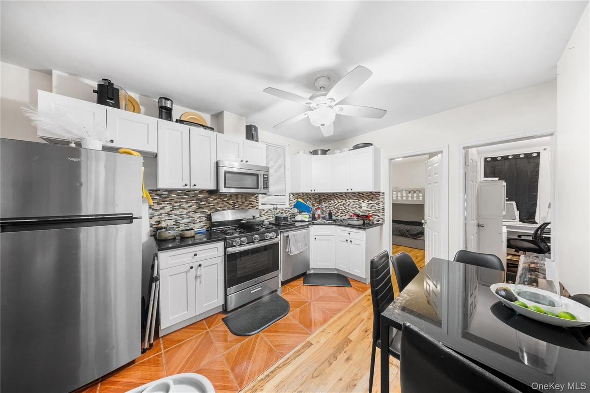Kitchen with appliances with stainless steel finishes, decorative backsplash, and white cabinets