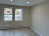 Unfurnished room featuring light wood-style flooring, a baseboard radiator, and recessed lighting