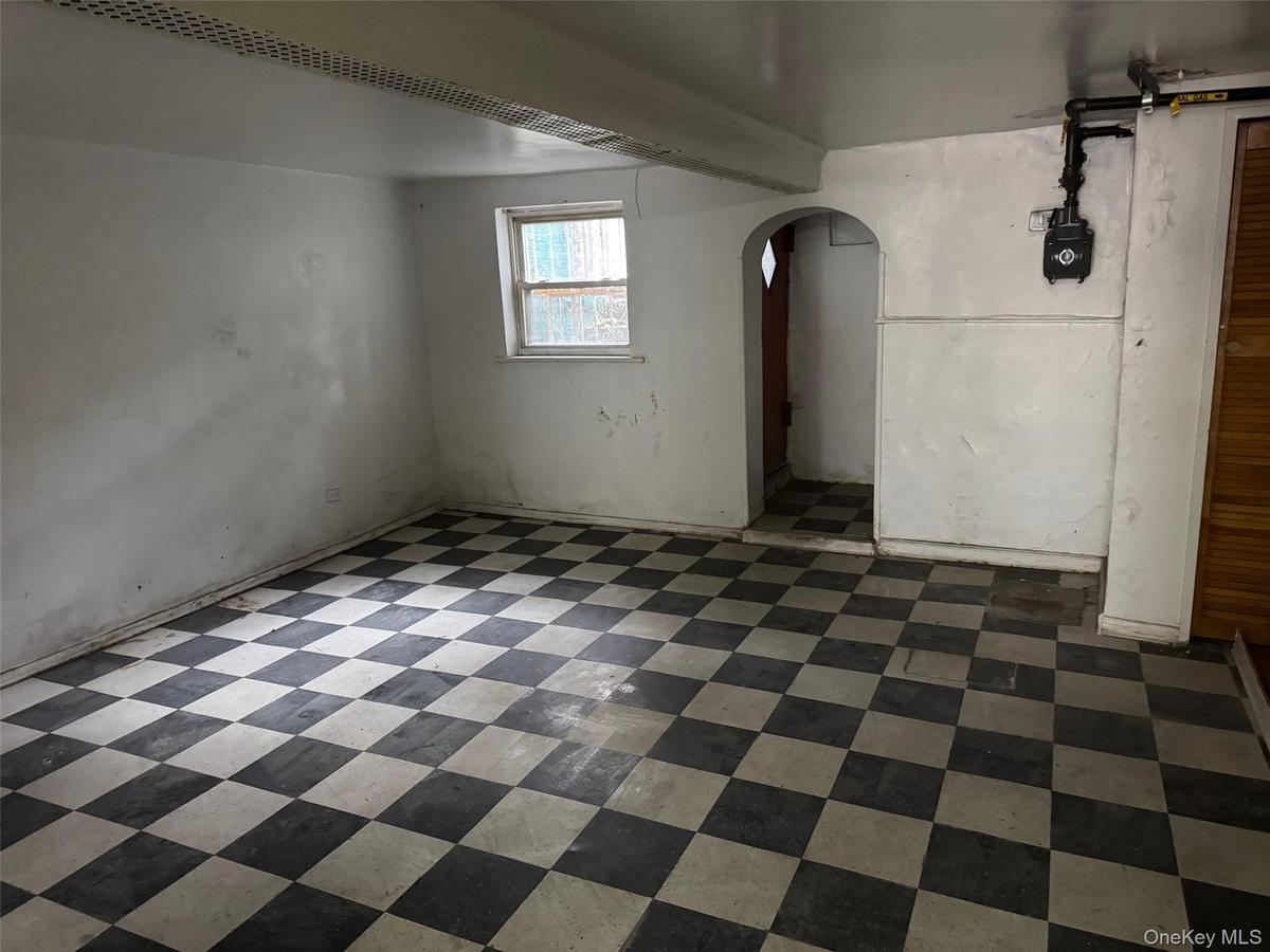 Below grade area featuring arched walkways and dark flooring
