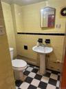 Half bathroom with tile walls and dark floors