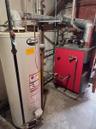 Utility room with gas water heater and a heating unit