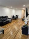 Living room with light wood-type flooring and recessed lighting