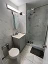Bathroom with tile walls, a marble finish shower, vanity, and light marble finish flooring