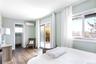 Bedroom with hardwood / wood-style flooring, access to outside, a wall unit AC, and a baseboard heating unit
