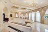 Bedroom featuring a decorative wall, a chandelier, ornamental molding, multiple windows, and a wainscoted wall