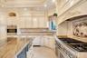 Kitchen featuring backsplash, light stone countertops, stainless steel appliances, crown molding, and recessed lighting