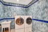 Washroom featuring tile walls and washer and clothes dryer