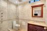 Bathroom with tile walls, vanity, a shower stall, and tile patterned flooring