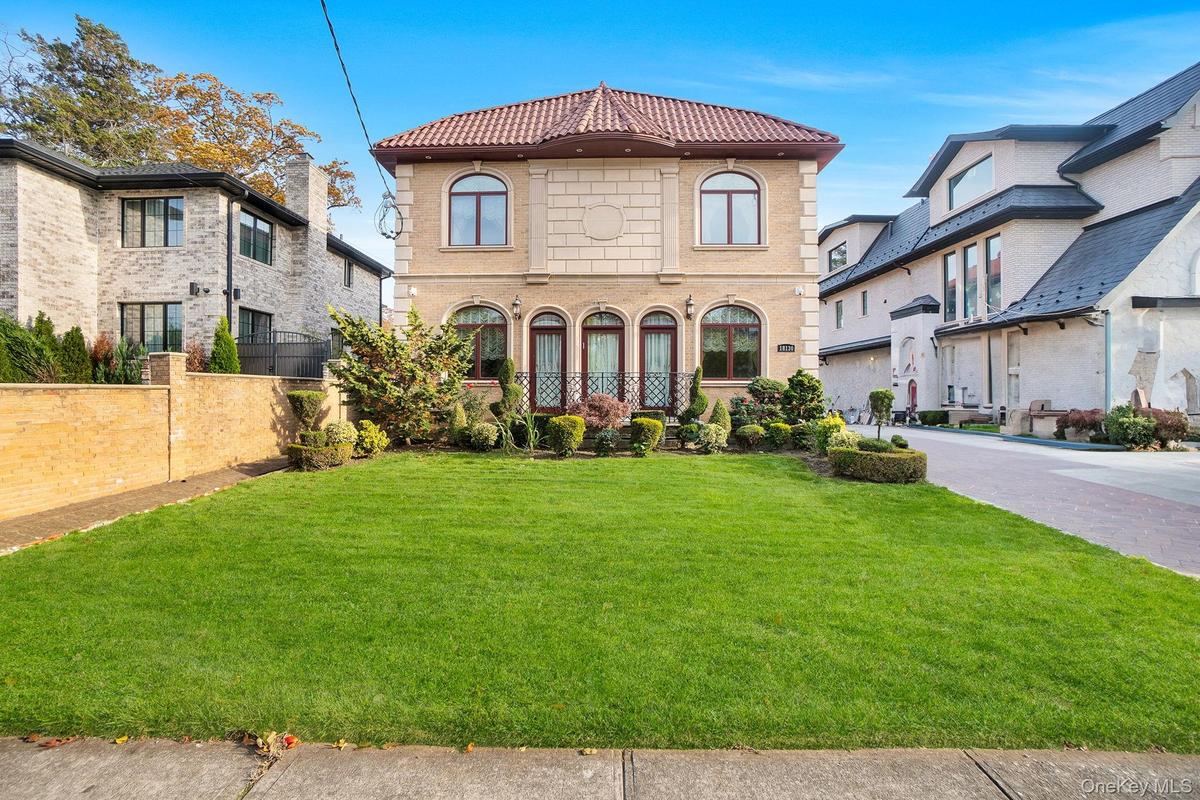 View of front facade featuring a tiled roof and driveway
