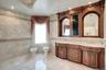 Bathroom featuring tile walls, light tile patterned floors, double vanity, recessed lighting, and a bidet