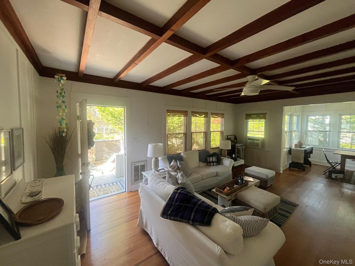 Living area with wood finished floors, beamed ceiling, ceiling fan, and coffered ceiling