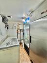 Kitchen featuring light tile patterned flooring, heating unit, and freestanding refrigerator