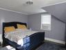 Bedroom with dark wood finished floors, ornamental molding, and a chandelier