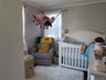 Bedroom with crown molding, a nursery area, and carpet