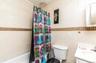 Bathroom with vanity, shower / tub combo with curtain, and tile walls