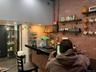 Bar area featuring brick wall, electric panel, dark wood finished floors, and open shelves
