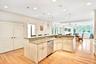Kitchen island with recessed lighting, decorative light fixtures, light wood-style flooring, a center island with sink, and stainless steel Bosch dish