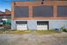 Back of property featuring an attached garage and brick siding