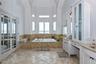 Bathroom featuring a high ceiling, french doors, tiled bath, and vanity