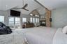 Bedroom with access to outside, carpet, ceiling fan, high vaulted ceiling, and a multi sided fireplace