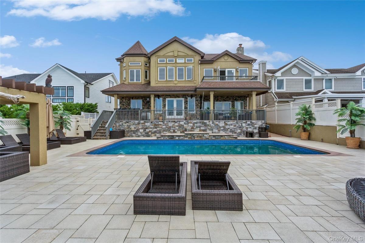 Back of property with a fenced in pool and a patio