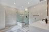 Bathroom with vanity, tile walls, a marble finish shower, and recessed lighting