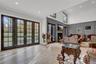 Living room featuring french doors, a decorative wall, hardwood / wood-style floors, a glass covered fireplace, and ornamental molding