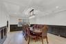 Dining room featuring a wainscoted wall, a decorative wall, coffered ceiling, and light wood-style flooring