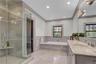 Primary Full bath #1 featuring a wainscoted wall, a decorative wall, vanity, a shower stall, and a bath