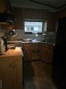Kitchen featuring ventilation hood, refrigerator, tasteful backsplash, range, and lofted ceiling