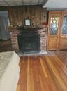 Living area with wood walls, a fireplace, and hardwood / wood-style flooring