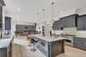Kitchen featuring backsplash, light stone countertops, appliances with stainless steel finishes, recessed lighting, and ornamental molding