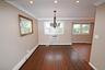 Unfurnished dining area with a baseboard heating unit, crown molding, dark wood-style flooring, a chandelier, and a wall mounted AC