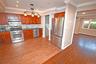 Kitchen featuring crown molding, stainless steel appliances, decorative backsplash, pendant lighting, and dark wood-type flooring