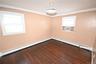 Empty room featuring a baseboard heating unit, dark wood-style floors, ornamental molding, and cooling unit