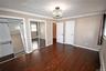 Unfurnished bedroom with two closets, ornamental molding, dark wood-style floors, and baseboard heating