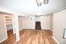 Finished basement featuring stairway, light wood finished floors, and baseboard heating