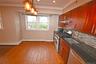 Kitchen featuring stainless steel appliances, dark stone countertops, crown molding, decorative backsplash, and hanging light fixtures