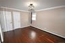 Unfurnished bedroom featuring baseboard heating, ornamental molding, and dark wood-type flooring
