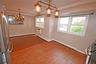 Unfurnished dining area featuring a chandelier, ornamental molding, dark wood-type flooring, a baseboard radiator, and recessed lighting