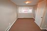 Unfurnished bedroom with baseboard heating and carpet