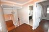 Hallway with an upstairs landing, ornamental molding, dark wood-style floors, a chandelier, and a baseboard heating unit