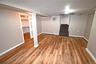 Finished below grade area featuring stairs, light wood-style floors, and a baseboard heating unit