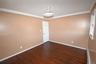 Empty room with ornamental molding, dark wood-style floors, and a baseboard heating unit