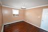 Empty room featuring crown molding, dark wood-style floors, baseboard heating, and cooling unit