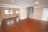 Unfurnished living room with crown molding, recessed lighting, stairway, a wall mounted air conditioner, and dark wood-type flooring